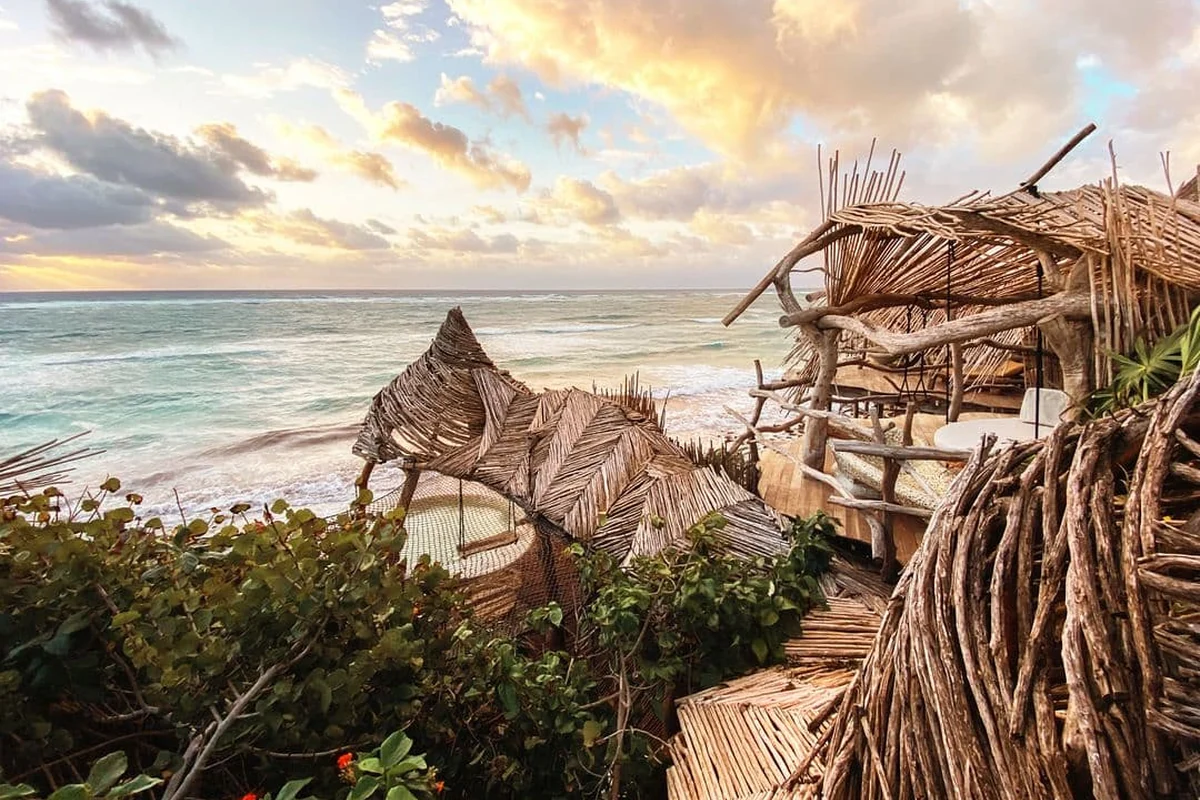 Arquitetura orgânica de um refúgio à beira do mar ao pôr do sol